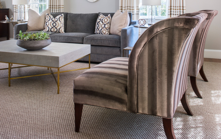 A pair of elegantly curved chairs upholstered in lush, mink-hued velvet by Blue Jay Design of Wellesley, MA
