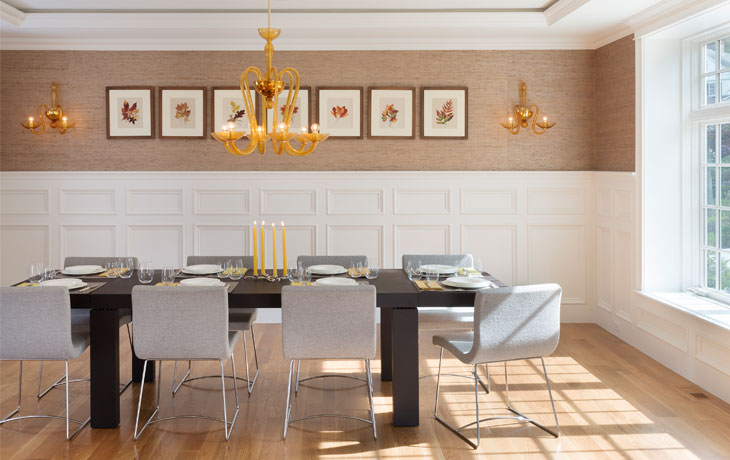 Traditional millwork meets contemporary furnishings and lighting in a dining room by Blue Jay Design of Wellesley, MA