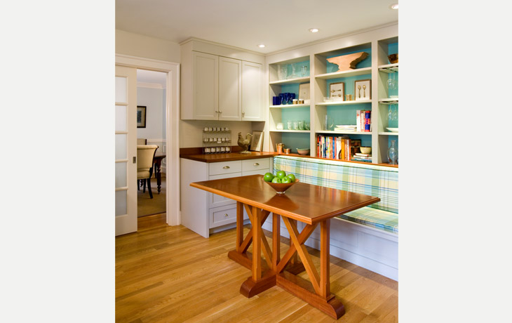 A custom table, bench, and shelving provide a casual family eating area by Blue Jay Design of Wellesley, MA