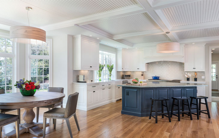 A generous, painted island provides contrast in a kitchen by Blue Jay Design of Wellesley, MA