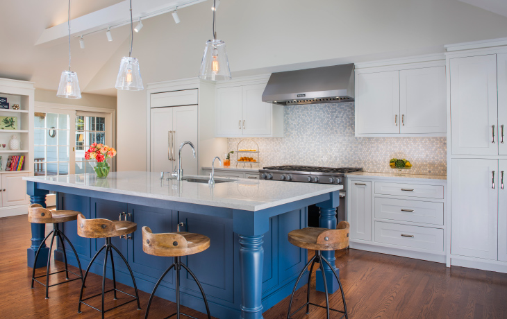 An oversized island painted in a saturated blue anchors this sleek contemporary kitchen by Blue Jay Design of Wellesley, MA