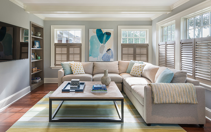 Custom wood shutters allow for privacy in the cozy family room by Blue Jay Design of Wellesley, MA