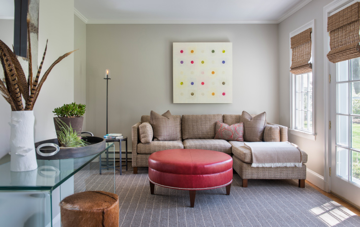 A dash of red and modern art liven up a comfortable family room by Blue Jay Design of Wellesley, MA