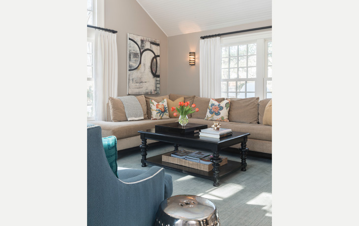 Strong accents complement the neutral furnishings in a family room by Blue Jay Design of Wellesley, MA