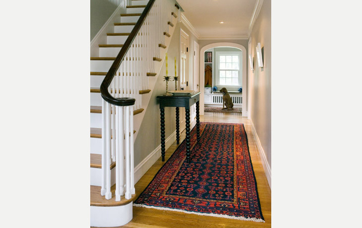 A bold Oriental rug anchors a simple entry way by Blue Jay Design of Wellesley, MA